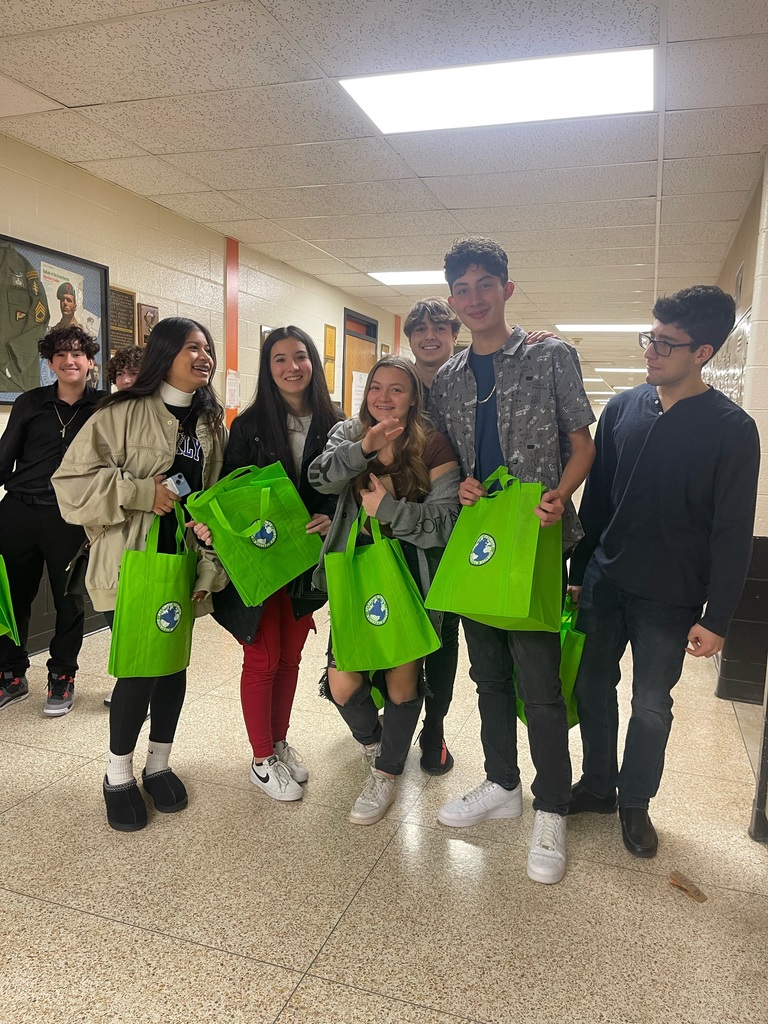 group of male and female students posting for the camera holding lime green bags
