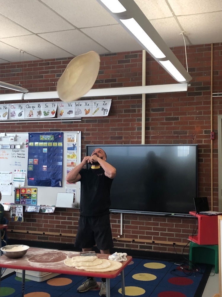 guy throwing pizza dough up in the air